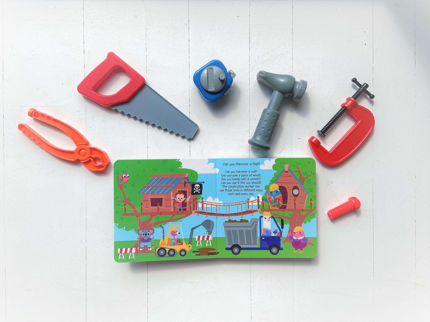 Ditty Bird’s Career Songs set features colorful toy tools—saw, pliers, hand drill, clamp, screw, and bolt—arranged around the interactive Career Songs book on a white surface, perfect for preschoolers.