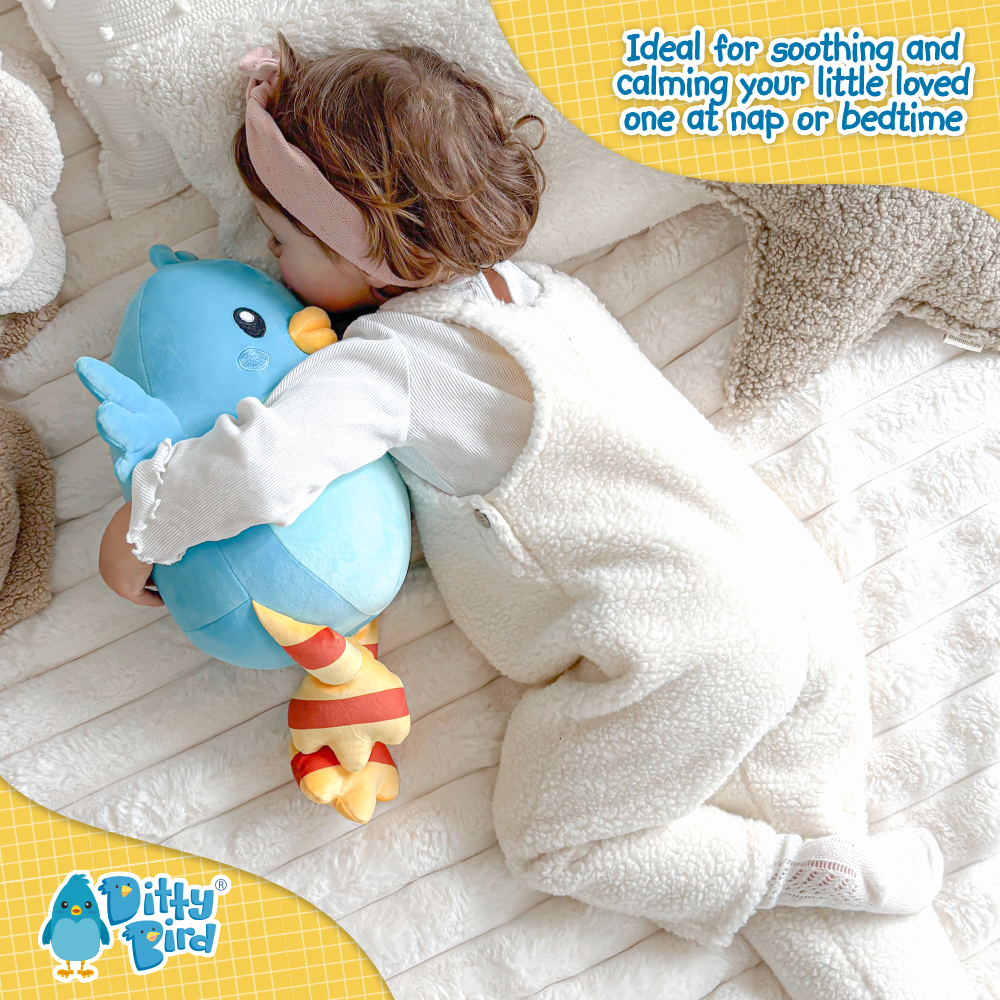 A toddler in white cuddles the NEW! Ditty Bird Squishy Soft Plush by Ditty Bird on a soft blanket. Text: Perfect for soothing and calming your little one at nap or bedtime. Inspired by the beloved musical book series.