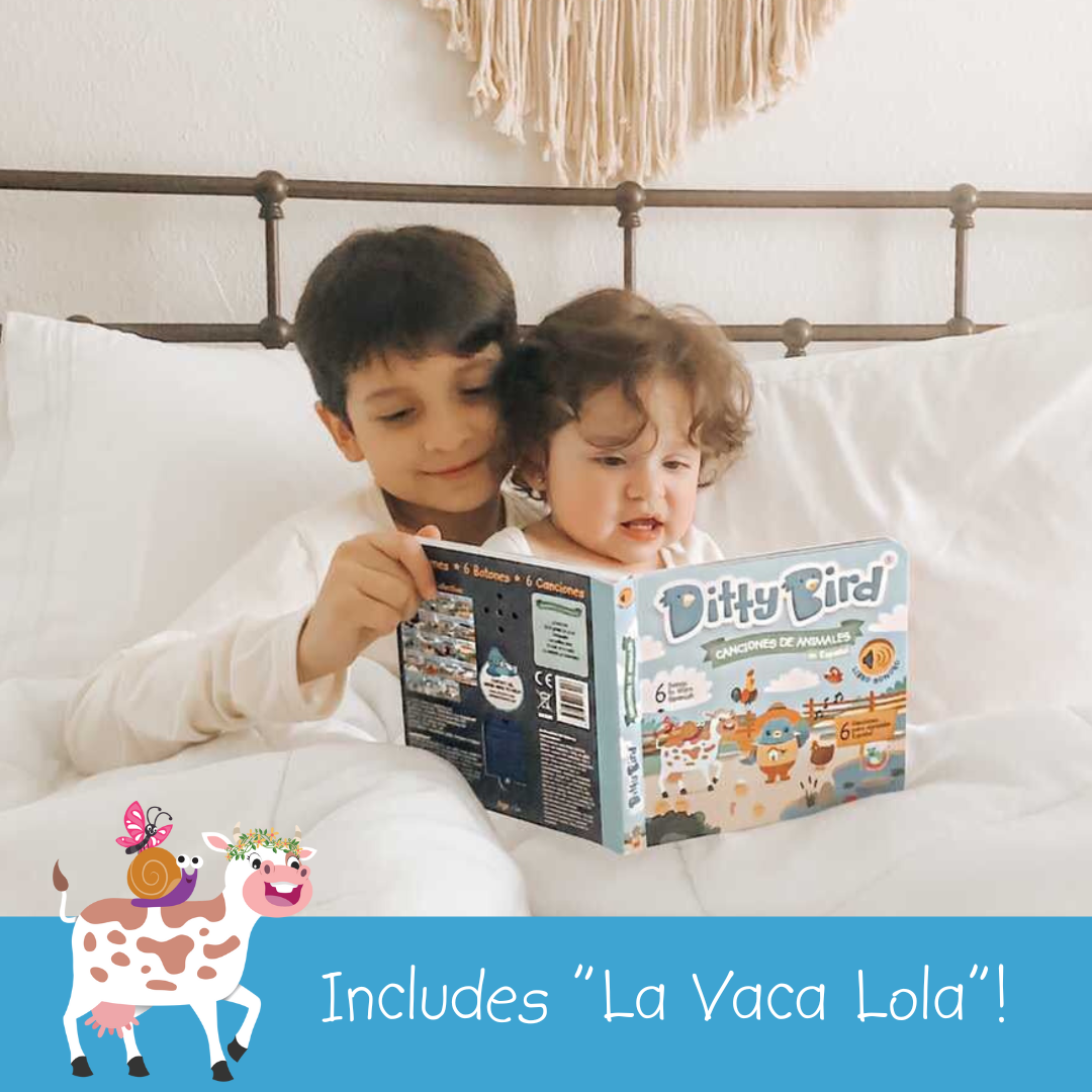 Two young children smile in bed as they read Ditty Bird’s "Canciones de Animales en Español," a sound book featuring Spanish animal songs. An illustrated cow and the text “Incluye La Vaca Lola!” appear at the bottom.