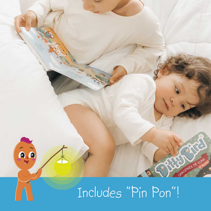 Two young children lie on a white bed reading Ditty Bird's Canciones de Cuna en Español. One baby holds the book as their sibling watches. An illustrated character with a lantern appears, and text reads: Includes Pin Pon! Spanish lullabies included.